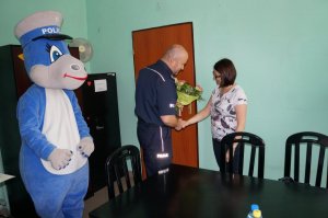 Komendant wręcza kwiaty mamie 9-latka.