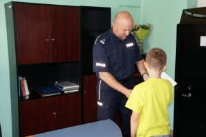 Komendant wręcza podziękowanie 9-latkowi.