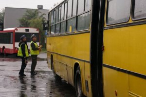 Policjanci drogówki stojący przy autobusie