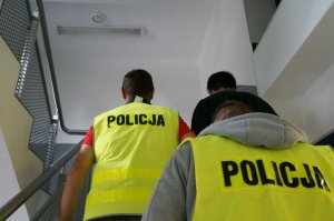 Mężczyzna doprowadzany przez policjantów