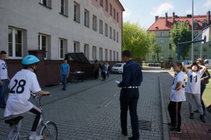 Policjant ruchu drogowego z grupką uczestników finału