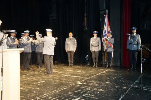 Orkiestra i poczet sztandarowy na scenie teatru