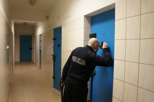 Policjant stojący przy drzwiach celi