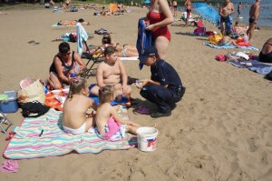 Policjantka rozmawia z plażowiczami
