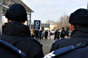 Widok policjantów stojących w szeregu zza ramion.