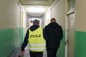 Policjanci prowadzą osobę zatrzymaną