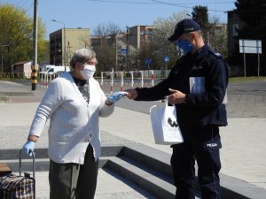Policjanci rozdający maseczki ochronne