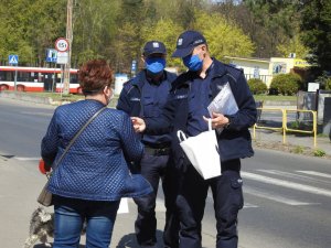 Policjanci rozdający maseczki ochronne
