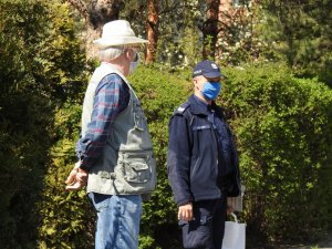 Policjanci rozdający maseczki ochronne