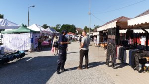 Policjant na targu rozmawia z mężczyzną