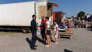 Policjant na targu rozmawia z kobietą i mężczyzną