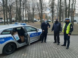 Komandant Powiatowy Policji w Będzinie oraz policjant ruchu drogowego wraz ze Starostą Powiatu Będzińskiego stojący obok radiowozu