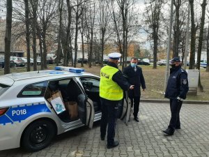 Komandant Powiatowy Policji w Będzinie oraz policjant ruchu drogowego wraz ze Starostą Powiatu Będzińskiego stojący obok radiowozu