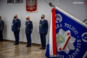 Sztandar Komendy Wojewódzkiej Policji w Katowicach, w tle kierownictwo Policji