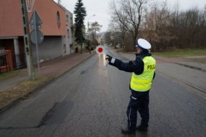 Policjantka dająca sygnał do zatrzymania auta