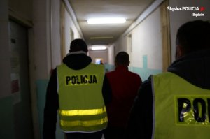 Policjanci prowadzą zatrzymanego