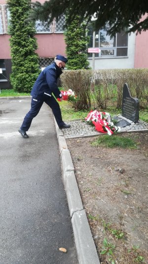 Komendant Komisariatu w Czeladzi składający kwiaty pod obeliskiem.