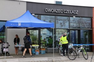 Zdjęcie przedstawia dworzec autobusowo-tramwajowy w Czeladzi. Przed dworcem znajdują się rowerzyści wraz ze swoimi rowerami, a także osoby biorące udział w oficjalnym otwarciu.