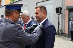 Policjant wręczający medal Staroście Będzińskiemu