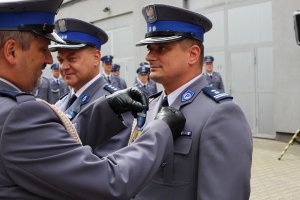 Policjant wręczający medal Zastępcy Komendanta Powiatowego Policji w Będzinie