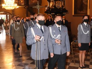 Policjanci tworzący asystę liturgiczną podczas wejścia do kościoła.