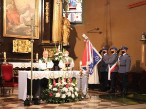 w centralnej części znajdują się księża prowadzący Mszę Świętą przy ołtarzu, po prawej stronie znajdują się policjanci tworzący Sztandar Komendy Powiatowej Policji w Będzinie.