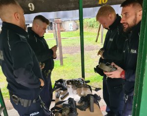 Policjanci ładujący magazynki i przygotowujący się do strzelania.