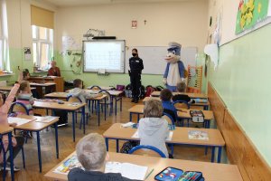 Umundurowana policjantka przemawiająca do uczniów w klasie .