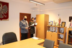 Komendant Powiatowy Policji w Będzinie oraz stojąca obok niego Specjalistka Zespołu Kadr i Szkolenia będzińskiej komendy.
