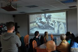 Sala odpraw katowickiej komendy wojewódzkiej. Na sali znajdują się przedstawiciele mediów i młodzież, którzy oglądają przygotowany przez policjantów spot.