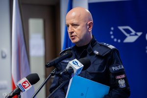 Przemawiający przed mikrofonami Komendant Główny Policji