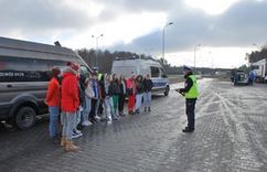 Zdjęcie kolorowe. Widoczny umundurowany policjant podczas działań Bezpieczne ferie i kontroli autokarów