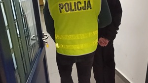 Policjant wyprowadzający zatrzymanego z policyjnego aresztu.