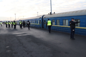 Grupa policjantów rozstawiona przy pociągu, który przyjechał z uchodźcami.