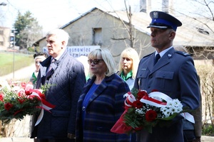 Komendant Komisariatu Policji w Czeladzi stojący z kwiatami obok kobiety i mężczyzny, którzy pełnią odpowiednio funkcję Zastępcy Burmistrza Czeladzi oraz Burmistrza Czeladzi.