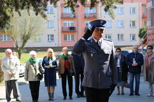 Komendant Komisariatu Policji w Czeladzi oddaje honor pod obeliskiem znajdującym się pod komisariatem.