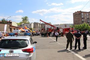 Na pierwszym planie radiowóz policyjny natomiast w oddali widzimy wszystkich zgromadzonych na placu będzińskiej straży pożarnej.