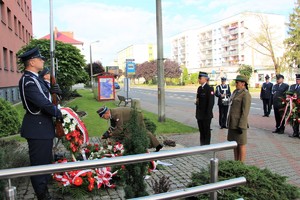Przedstawiciele służb mundurowych z powiatu będzińskiego składają kwiaty pod obeliskiem.