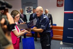 Uczestnicy konferencji. Na pierwszym planie umundurowany policjant i kobieta.