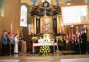 Zdjęcie robione w kościele, na środku znajduje się ołtarz oraz księża odprawiający Mszę Świętą, obok ołtarzy ustawione są sztandary.