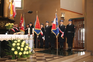 Zdjęcie przedstawia sztandary służb mundurowych ostawione obok ołtarzu w kościele.