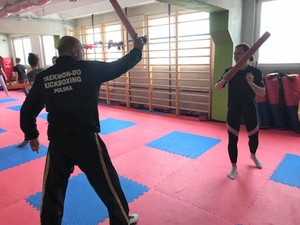 Policjantka trenuje na sali gimnastycznej z trenerem.