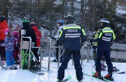 Zdjęcie, na którym widać dwóch policjantów w kombinezonach narciarskich.