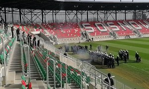 Zdjęcie, na którym umundurowani policjanci podczas szkolenia na stadionie piłkarskim.