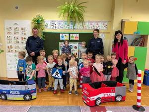 Zdjęcie grupowe na którym znajdują się policjantka, policjant, wychowawczyni oraz dzieci.