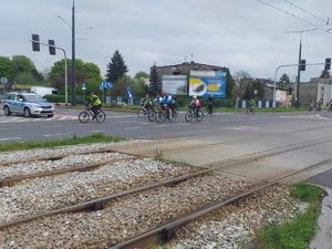 Na zdjęciu grupa rowerzystów, przejeżdżająca  przez skrzyżowanie.