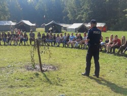 Zdjęcie przedstawiające policjanta i grupę ludzi