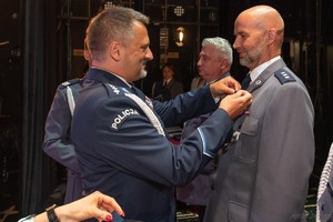 Na zdjęciu przewodniczący policyjnych związków zawodowych wręcza medal policjantowi.
