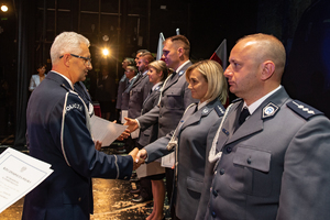 Komendant Wojewódzki Policji składa gratulację mianowanym policjantom, wręczając akty mianowania.