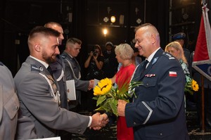 Komendant Powiatowy Policji w Będzinie wraz z Panią Wiceprezydent Będzina wręczają policjantom listy gratulacyjne i symboliczne kwiatki.